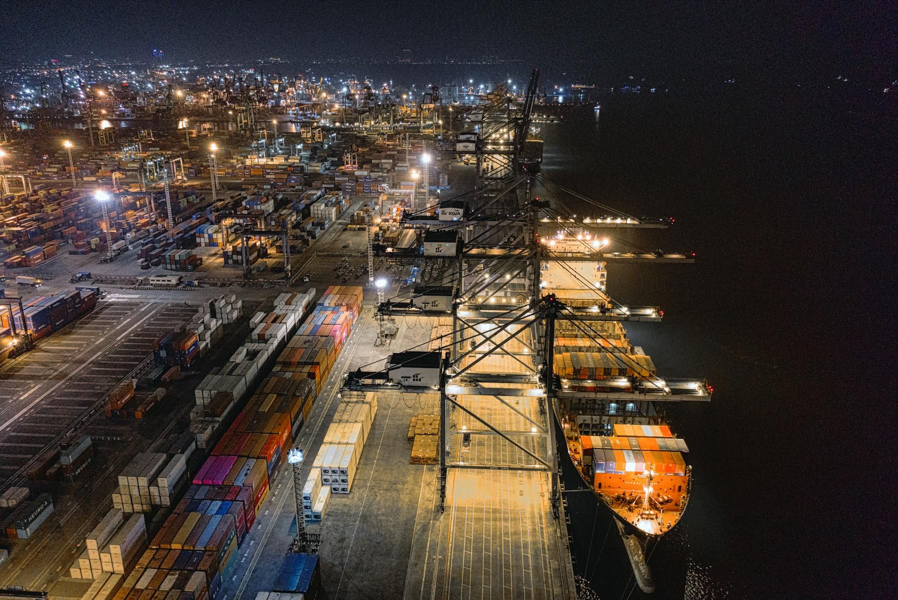Cargo ship traveling near a port facility.